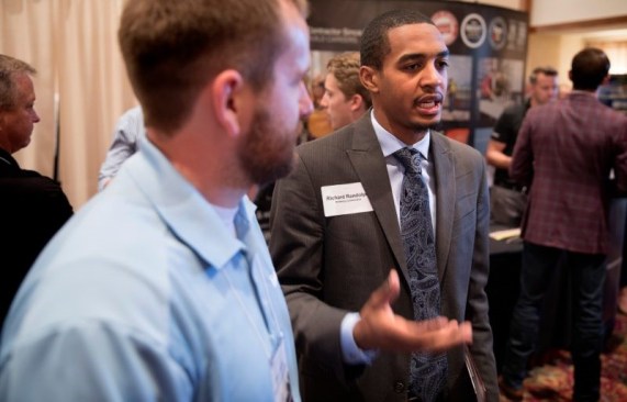 Myers-Lawson student Richard Randolph speaks with Turner Construction Company representatives during the career fair.