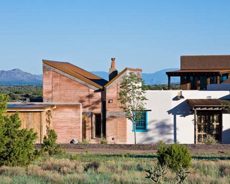 The home emulates several Southwestern styles, including pueblo revival and territorial. The rec room on the left was built with rammed earth, while the connecting structure is crafted using autoclaved aerated concrete.