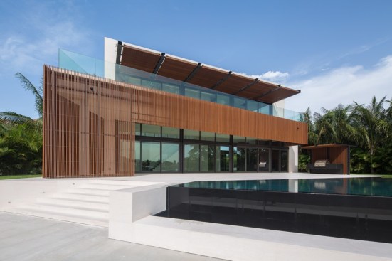 Beautiful and practical - the creative use of bio-based façade boards provides effective shading for this tropical home, a screen for outdoor cooking, and a warm balance to the cool aesthetic.